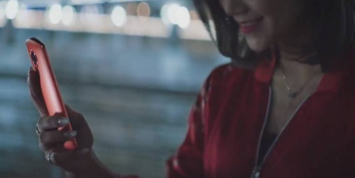 Woman wearing a red jacket and holding the Meitu T8